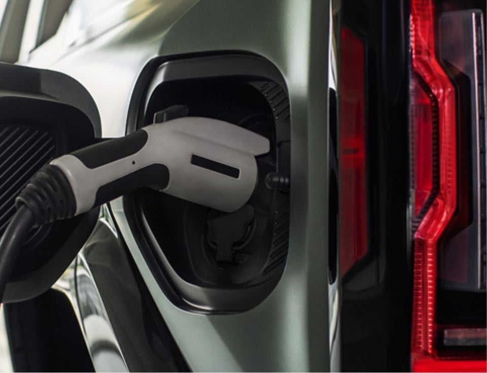 Close up of charging port with charger plugged in on a GMC Hummer EV SUV - Conley Buick GMC in BRADENTON FL